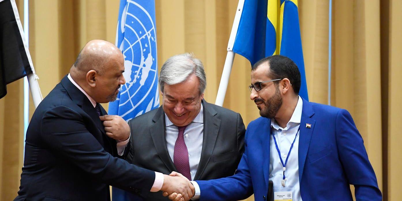 Jemens utrikesminister Khaled Hussein al-Yamani skakar hand med Mohammed Abdulsalam, ledare av Huthirebellernas delegation, i bakgrunden FN:s generalsekreterare António Guterres.