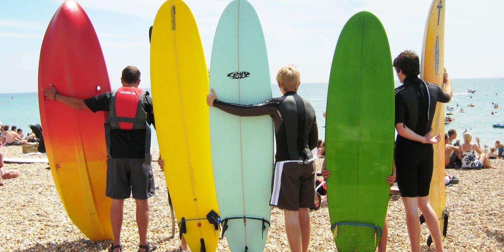 Surfare och solbadare, alla hänger på Brightons strand.