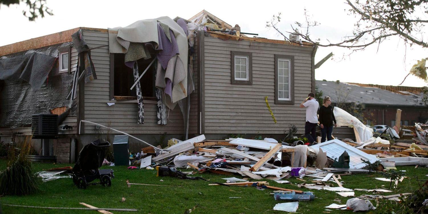 Ett par tittar till sitt hem som har fått omfattande skador i tornadon. Arkivbild.