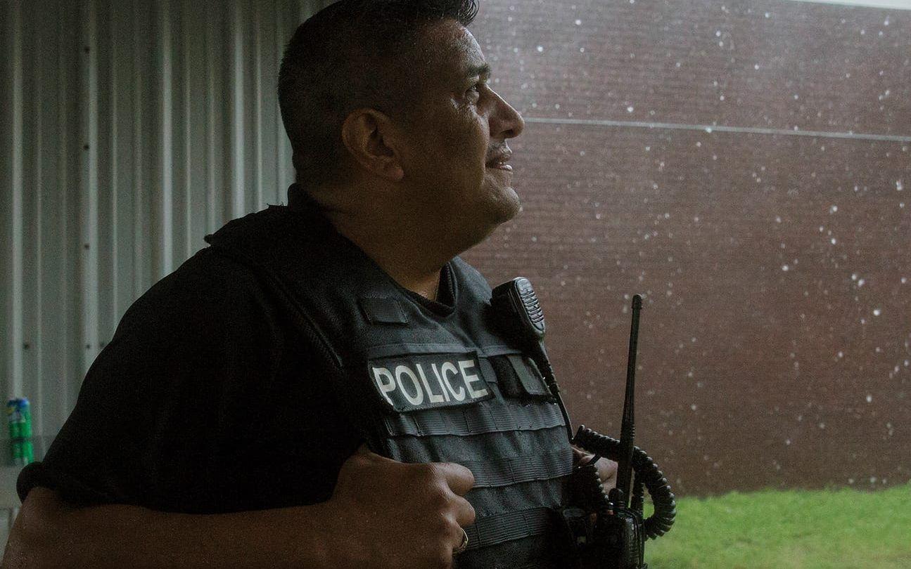 Polisen Javier Ramos vid Port Lavaca PD, tittar upp mot regnet som öser ner över staden. Polisen i staden har slutat att rycka ut på larm eftersom de starka vindbyarna gör det för farligt. FOTO: Ana Ramirez/The Victoria Advocate via AP
