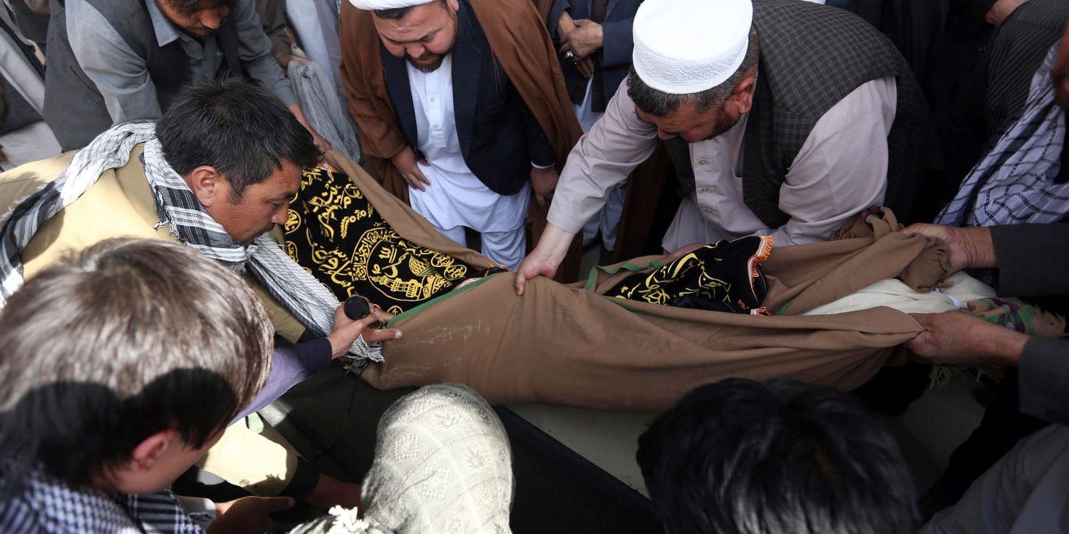 Ett av offren för självmordsdådet i Kabul bärs bort på bår.