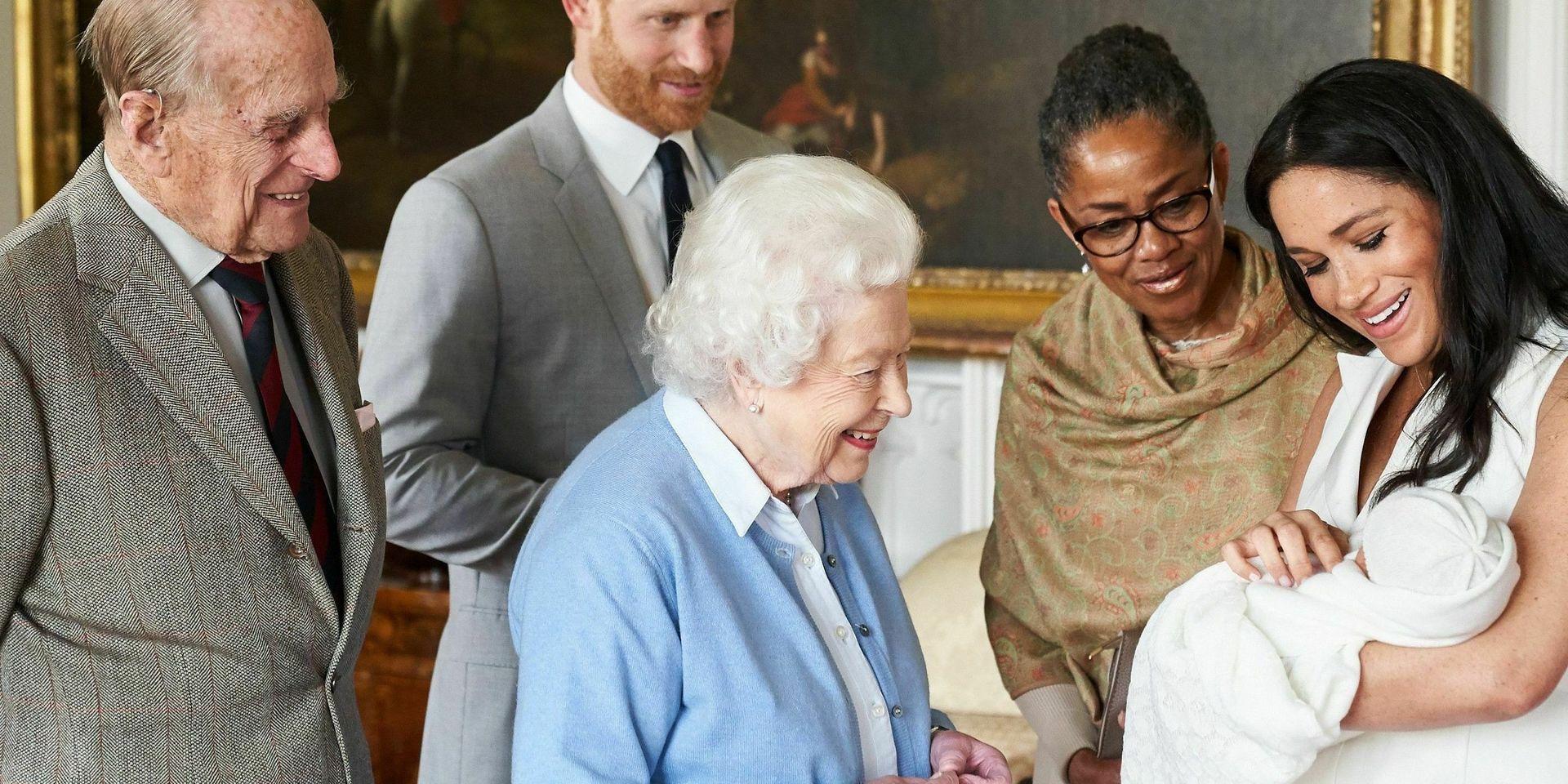 Drottning Elizabeth, och prins Philip, liksom Doria Ragland (mor till prins Harrys hustru Meghan) hälsar under överinseende av prins Harry och Meghan på Archie Harrison Mountbatten-Windsor. Arkivbild från maj 2019. 