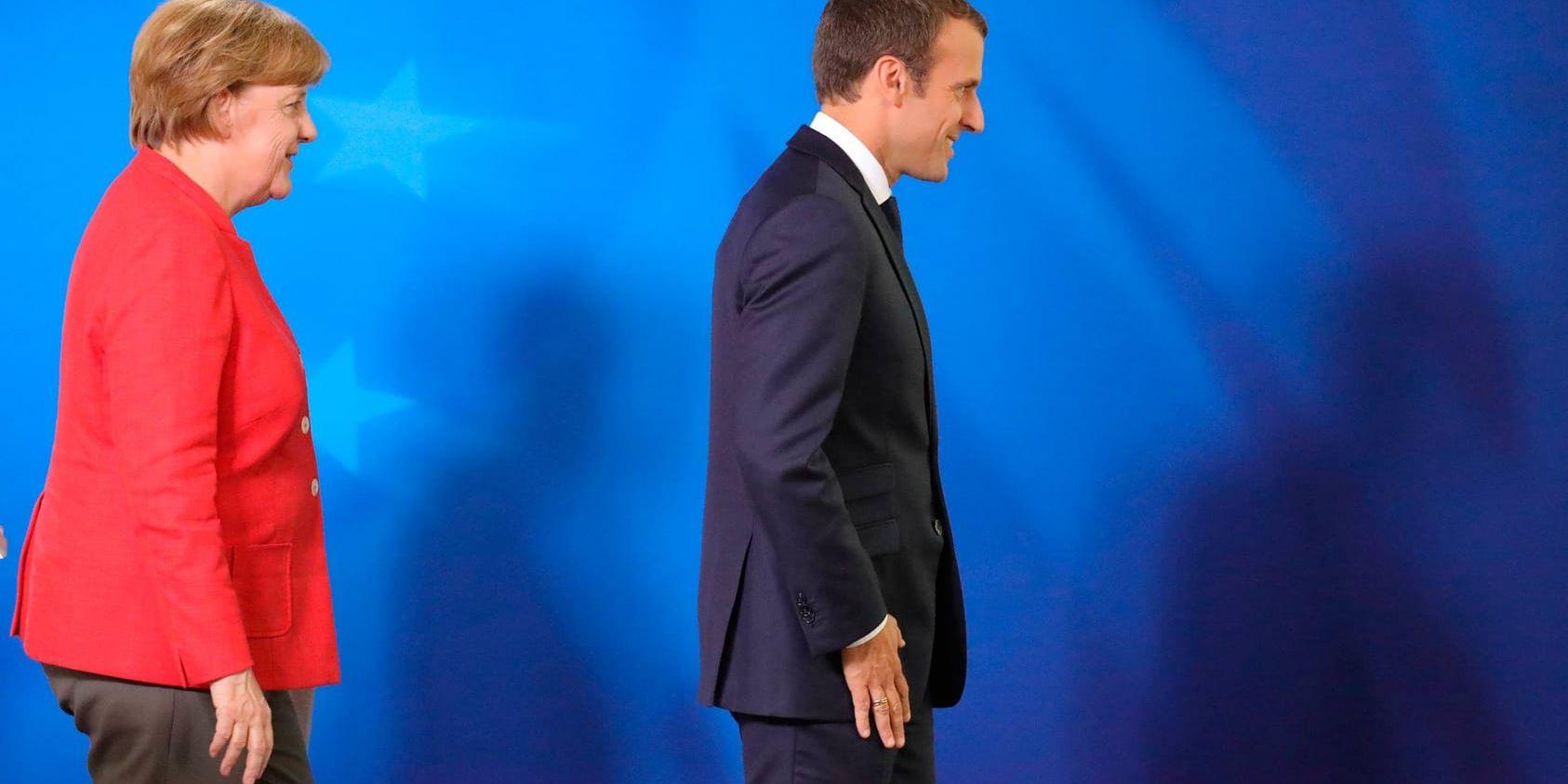 Tysklands förbundskansler Angela Merkel och Frankrikes president Emmanuel Macron kliver ner från podiet efter ett gemensamt tal vid EU-toppmötet i Bryssel.