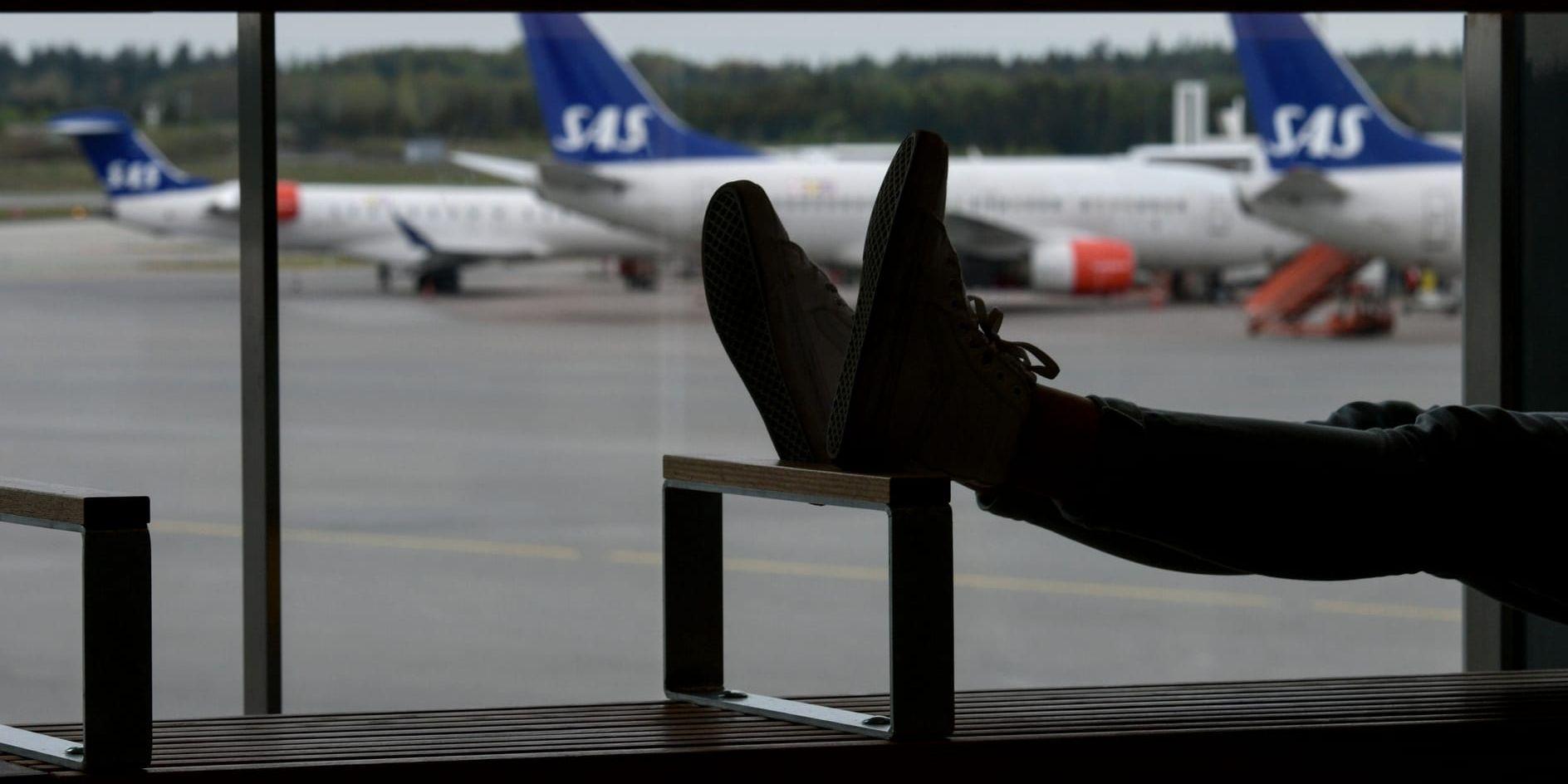 En passagerare vilar fötterna på Terminal 3 på Arlanda under flygstoppet. Arkivbild.
