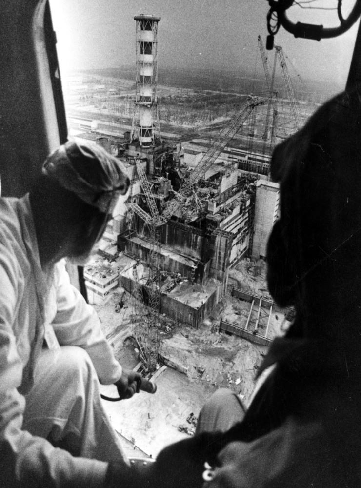 En helikopter cirklar över det fjärde reaktorblocket i Tjernobyl efter explosionen den 26 april 1986. Det 150 meter höga ventilationstornet var riktmärke för räddningsarbetarna. De ljusa och mörka partierna på marken är orsakade av besprutningen med det kemiska medlet &quot;Barda&quot; som band det radioaktiva dammet.
