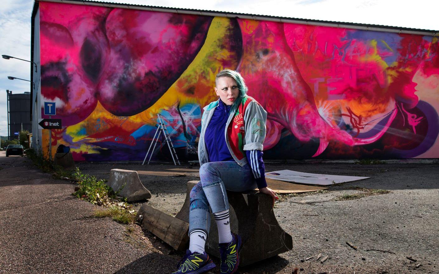 Carikuba Falkholt framför sin målning på Ringön som blev vandaliserad. Bild: Thomas Johansson