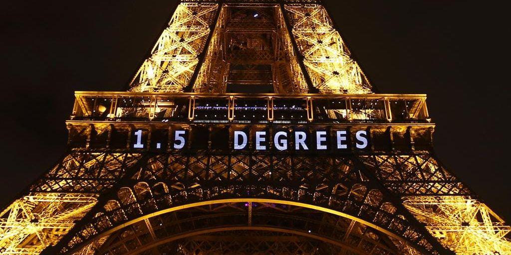 På Eiffeltornet i Paris projiceras en maning till delegaterna på klimatmötet att enas om åtgärder för att begränsa jordens uppvärmning till 1,5 grader.