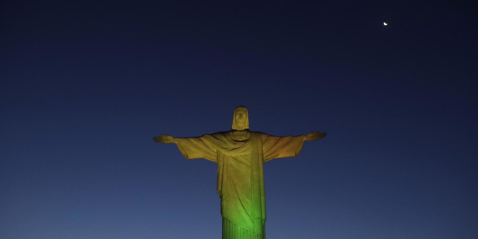 Karnevalen i Rio de Janeiro ställs in, då det inte bedöms vara möjligt heller i juli. Här har Jesusstatyn på den så kallade Sockertoppen lysts upp för att markera vaccinstarten tidigare i veckan.
