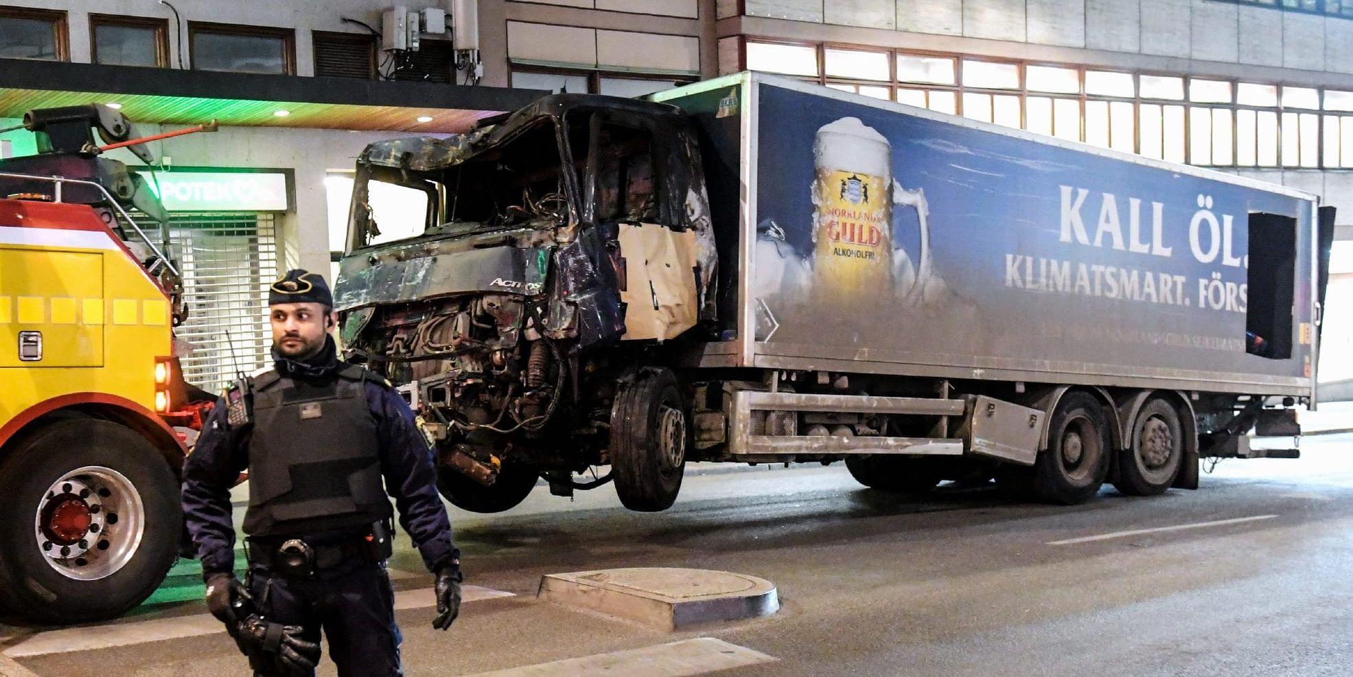 Lastbilen som användes vid attentatet i Stockholm i fredags bogseras bort från Drottninggatan.