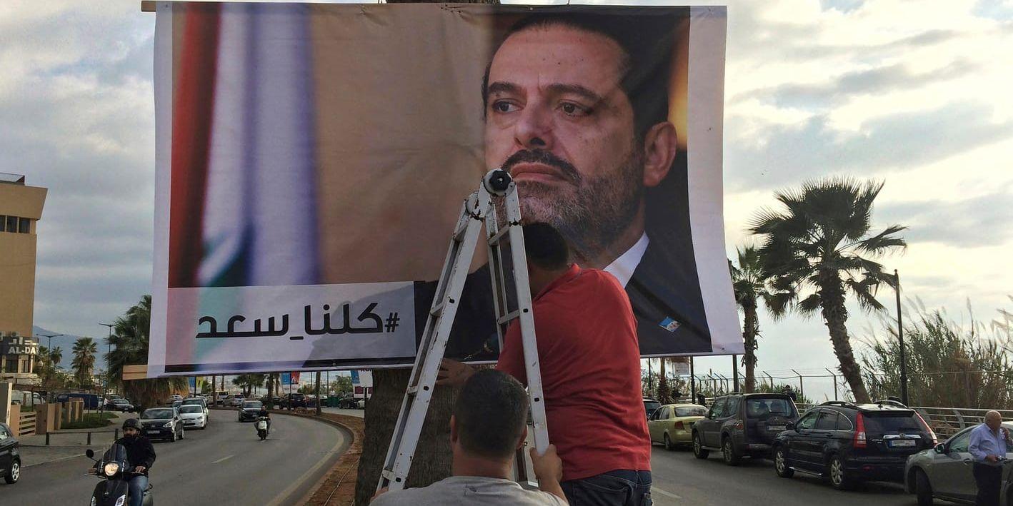 Arbetare i Libanons huvudstad Beirut hänger upp en affisch med premiärminister Saad al-Hariri, med texten "Vi är alla Saad". Arkivbild.