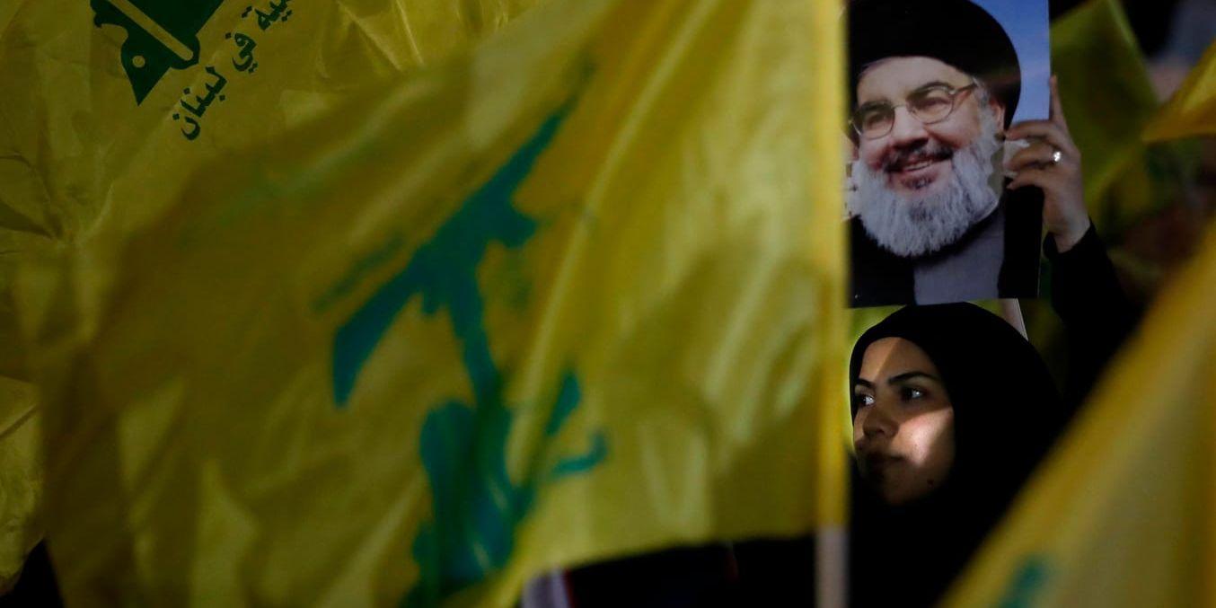 En Hizbollah-anhängare bär ett porträtt av rörelsens ledare Hassan Nasrallah, vars son nu terrorlistas i USA. Arkivbild från augusti.