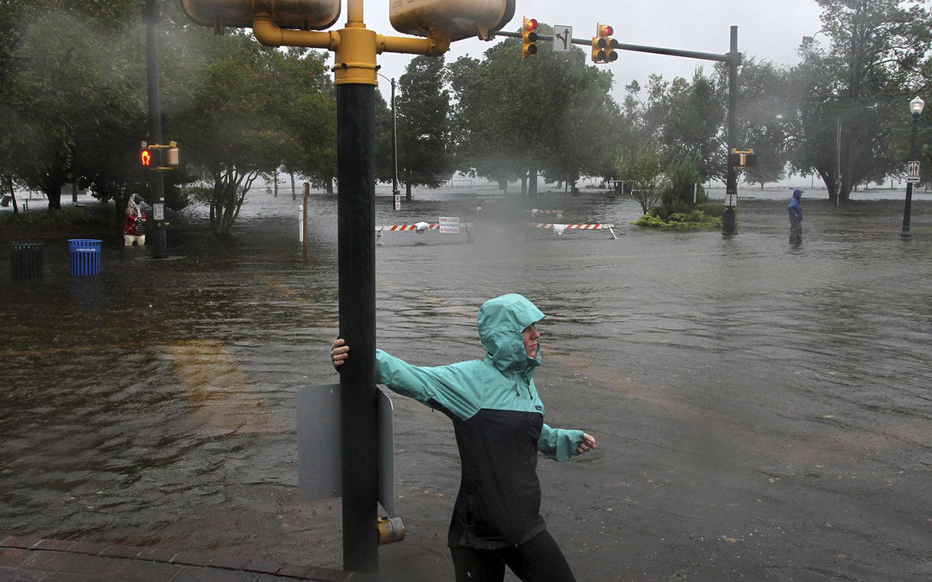Jamie Thompson går genom de översvämmade delarna av East Front Street nära Union Point Park i New Bern, North Carolina torsdagen den 13 september. FOTO: Gray Whitley/Sun Journal via AP