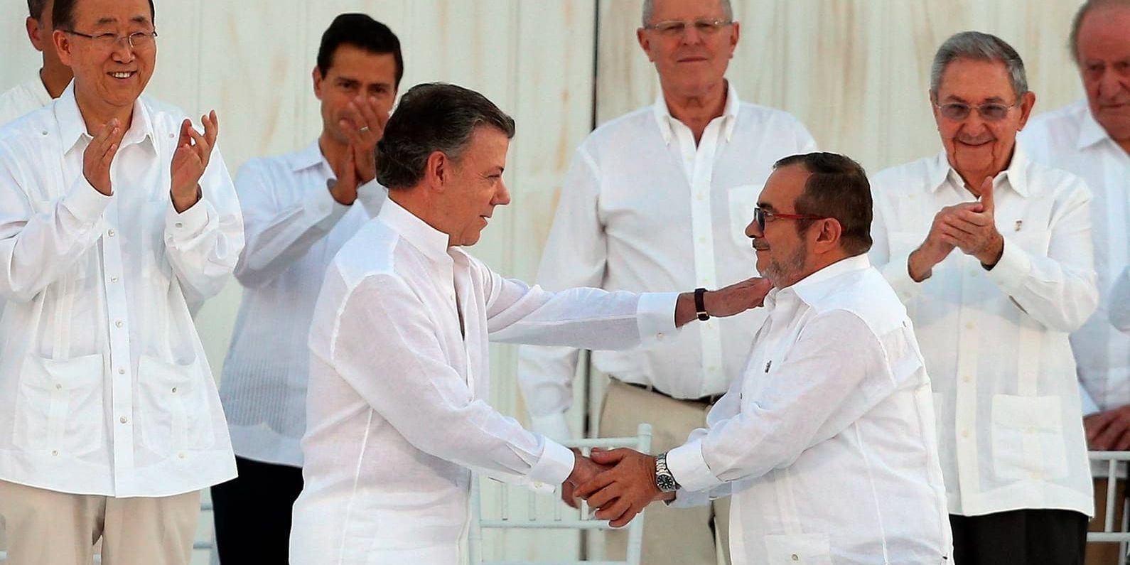 Colombias president Juan Manuel Santos och Farc-ledaren Timoléon Jiménez skakar hand under ceremonin i Cartagena.