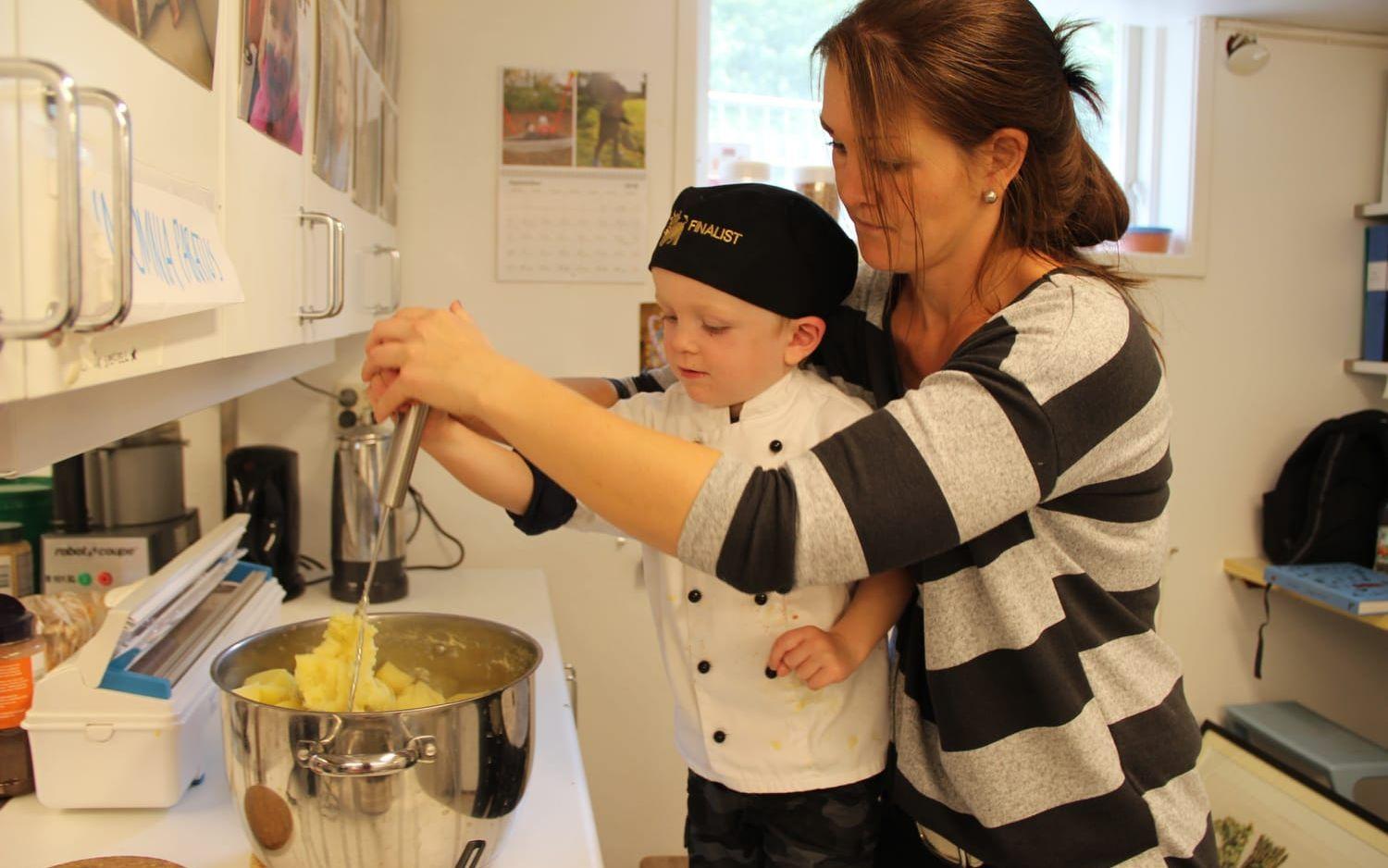 Elvis Sachse får hjälp av fritidspedagogen, tillika mamma, Anna Sachse att göra potatismos till biffarna. Bild: Camilla Moestedt