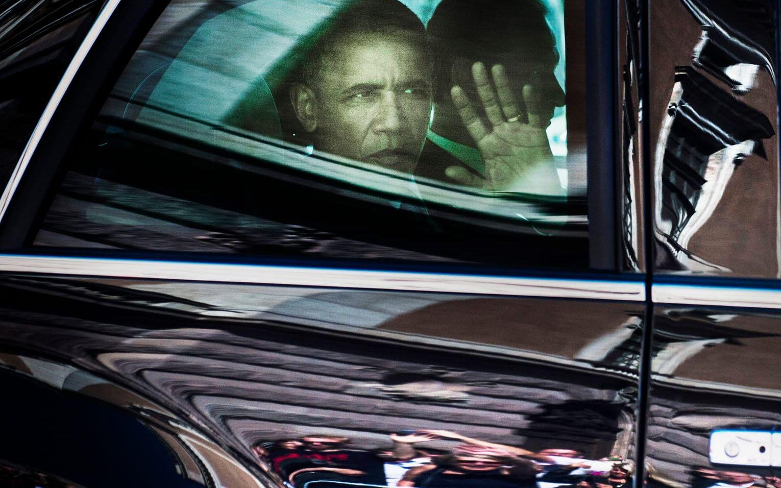 28 augusti, 2013: Obama gör ett besök Sverige. Här vinkar han ut genom fönstret på "The Beast" när han passerar slottet i Stockholm. Foto: TT