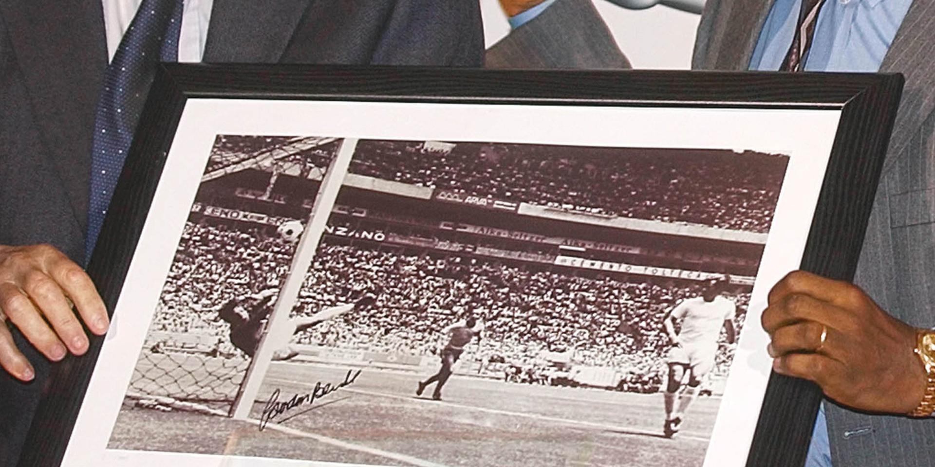 Gordon Banks och Pelé håller upp en tavla med målvaktens mest kända räddning – på Pelés nick i VM 1970. 