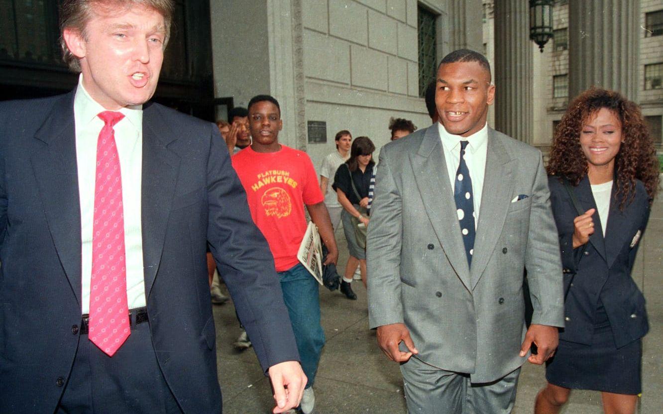 <strong>22 juli, 1988: </strong>Mike Tyson och Donald Trump blev vänner när boxaren i början av sin karriär gick matcher på Trump Plaza Casino. Trump såg snabbt hans talang och klev in som Tysons rådgivare. Här ser vi honom följa Mike Tyson till rätten om en tvist mellan boxaren och hans manager.  Foto: TT