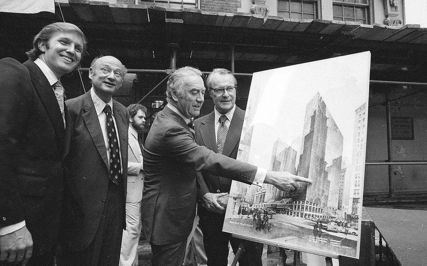 <strong>27 juni, 1978:</strong> Donald Trump, 32, intill en konceptbild av New York Hyatt Hotel. Vid hans sida står New Yorks guvernör Hugh Carey samt borgmästaren Ed Koch, som han skulle ha många fajter med, och Robert T Dormer. Foto: AP / TT
