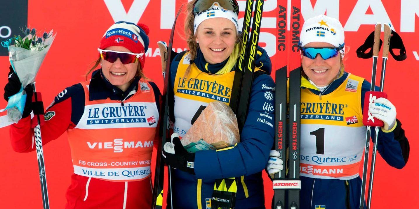 Stina Nilsson i en van position, överst på prispallen. Till vänster tvåan Maiken Caspersen Falla och till höger trean Hanna Falk.