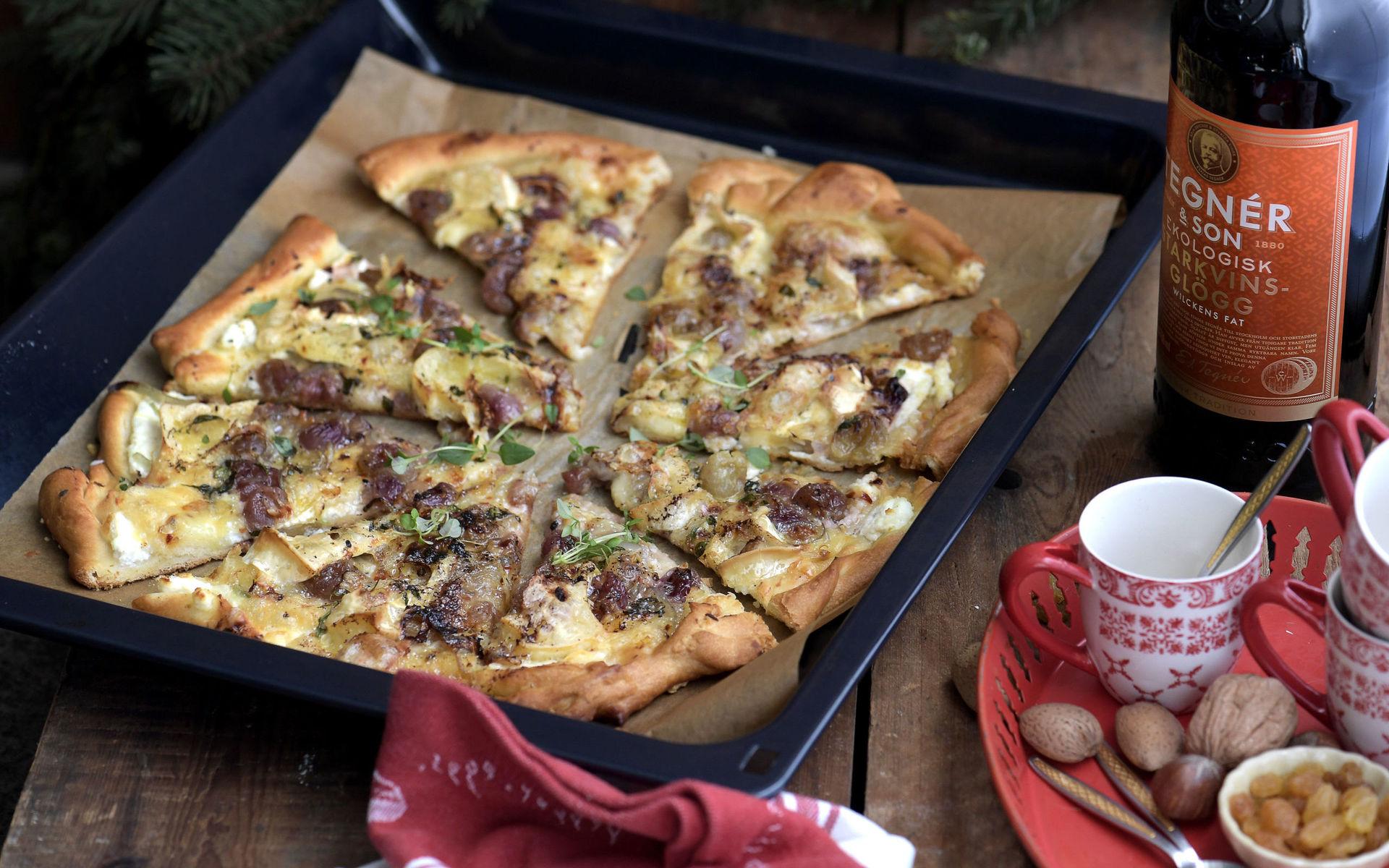 Vem har sagt att man inte kan servera pizza på glöggmingel? Den här är toppad med rostade vindruvor och brieost.