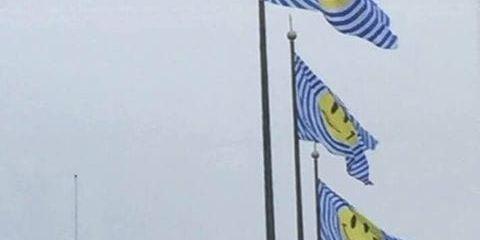 Tre flaggor med smileys vajade på Gustaf Adolfs torg.