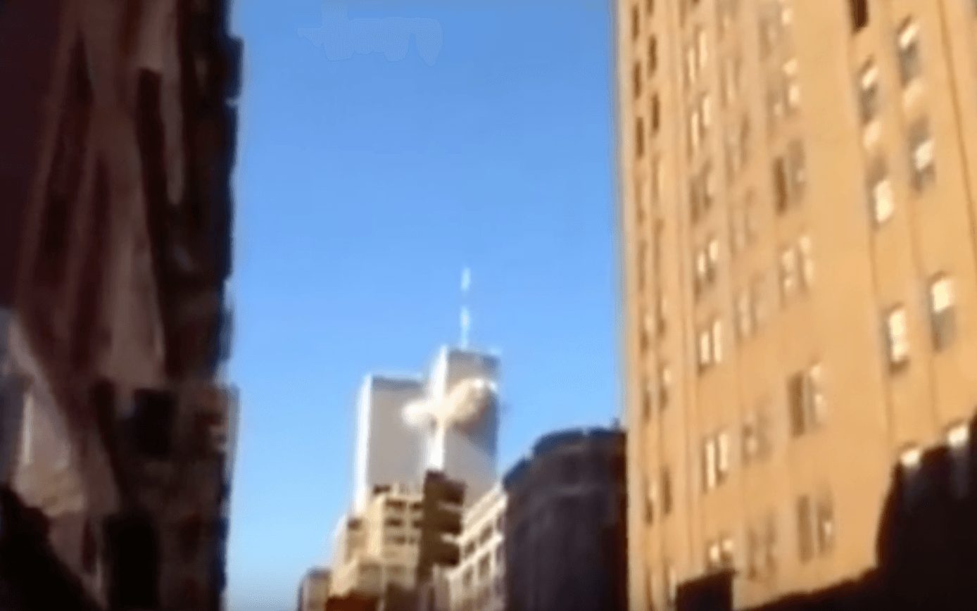 Klockan 08.46 den 11 september 2001 får ett enormt oväsen de flesta på Manhattans gator att titta upp mot skyn. Strax därefter kraschar American Airline 11 in i det norra tornet. Foto: Skärmdump Youtube