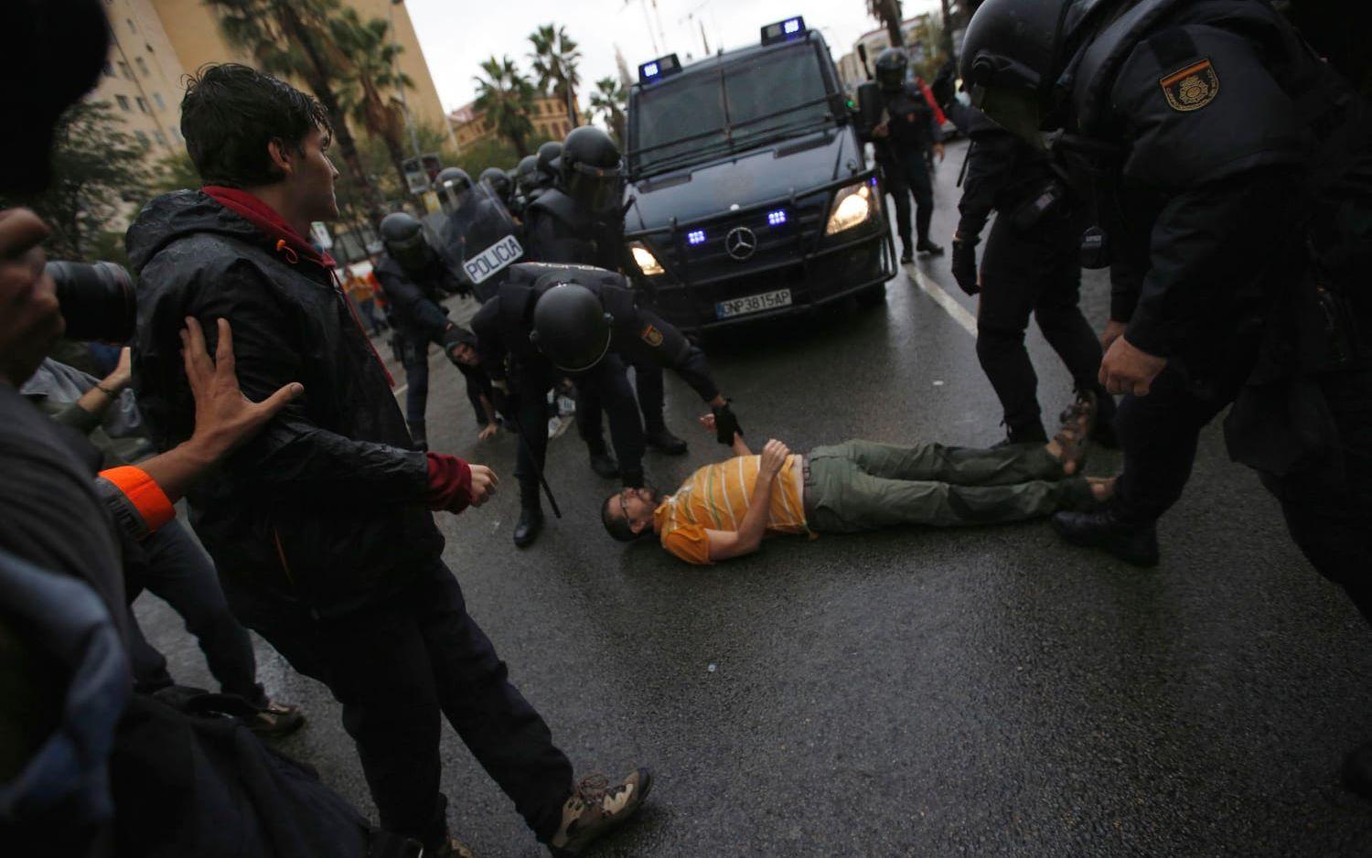En man har lagt sig på gatan i hopp om att stoppa polisen vid en vallokal i Barcelona.
