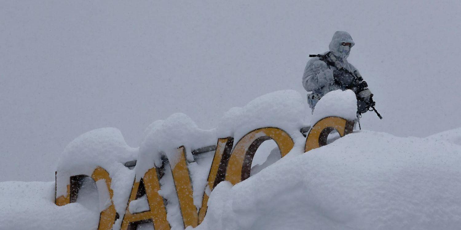 En rejält påpälsad polis håller utkik från ett hotelltak i det hårt bevakade Davos.