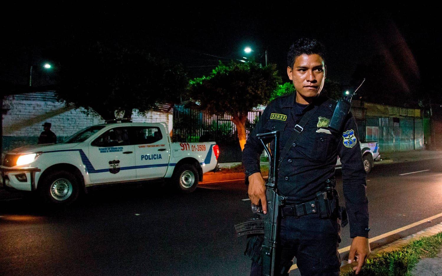 En polis på kvällspatrullering i San  Salvador.  Fortfarande dödas runt 10 personer om dagen i landet.