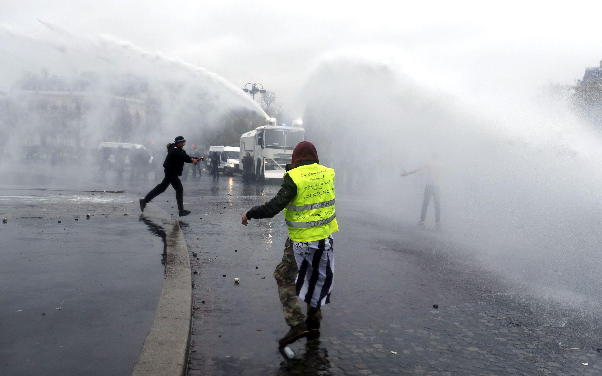 Polisen använder vattenkanoner mot demonstranterna.