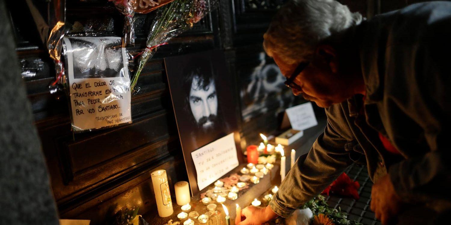 Människor tänder ljus vid en provisorisk minnesplats i Buenos Aires, för aktivisten Santiago Maldonado.