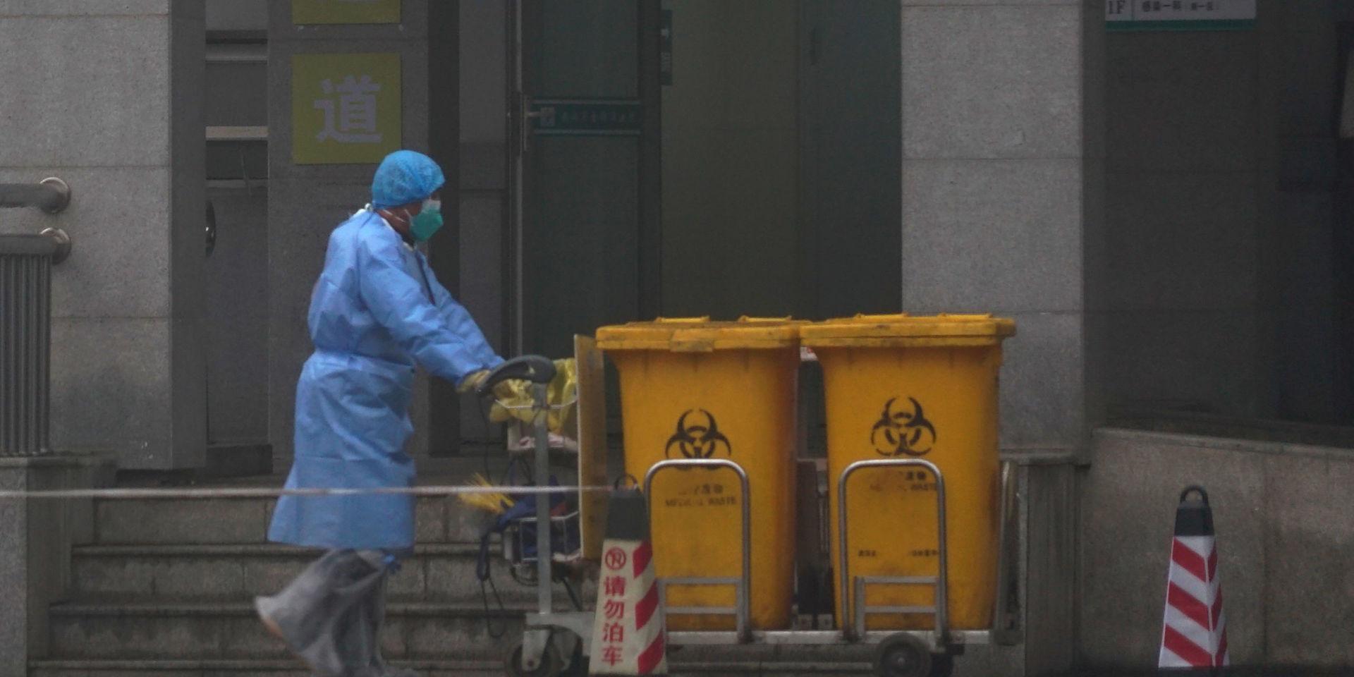 Personal flyttar behållare med farligt avfall vid entrén till Wuhan Medical Treatment Center i Kina, där några av de som smittats av de nya viruset vårdas. 