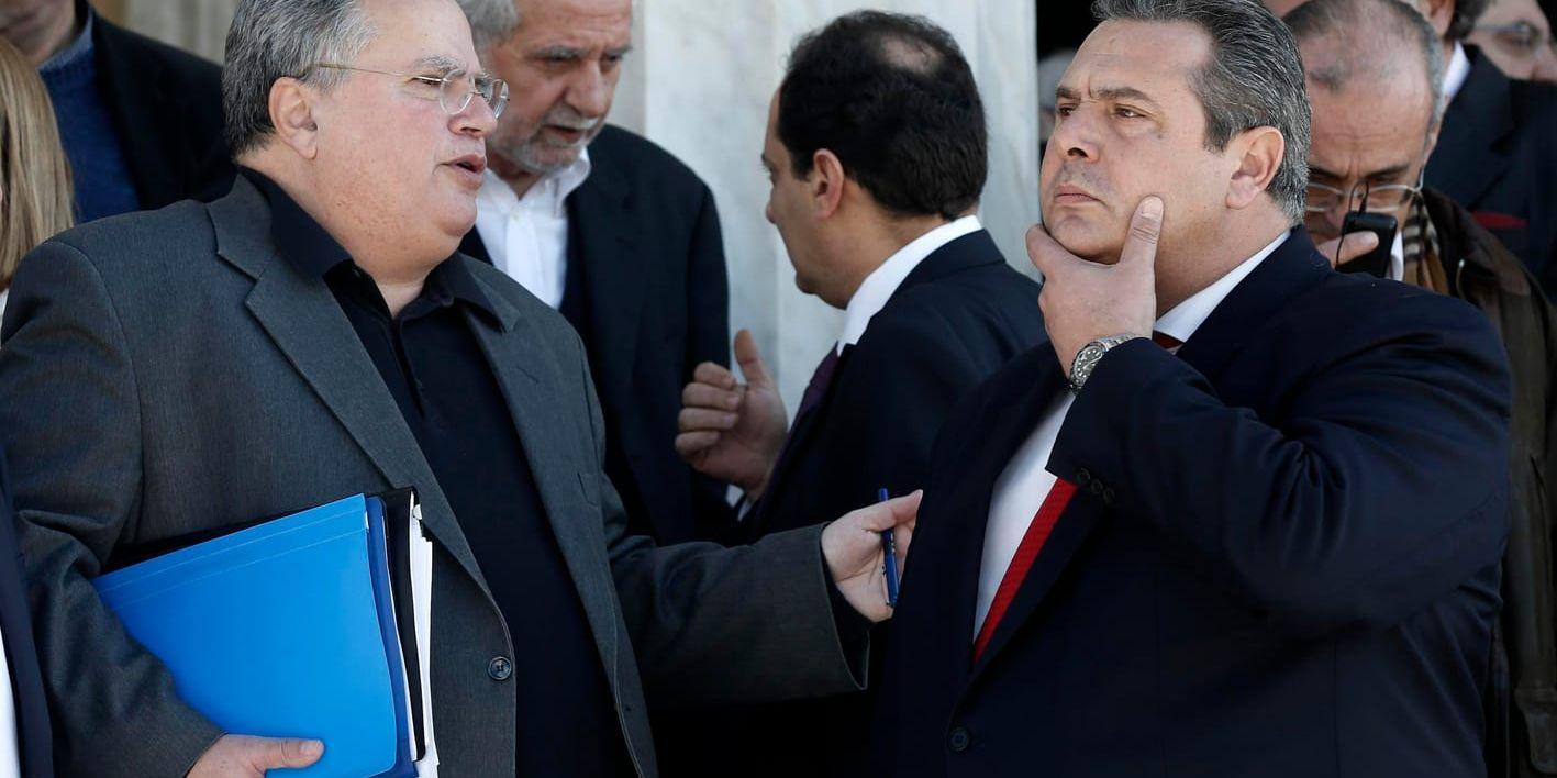 Greklands utrikesminister Nikos Kotzias, till vänster, i samspråk med försvarsminister Panos Kammenos utanför parlamentet i Aten 2015. Arkivbild.