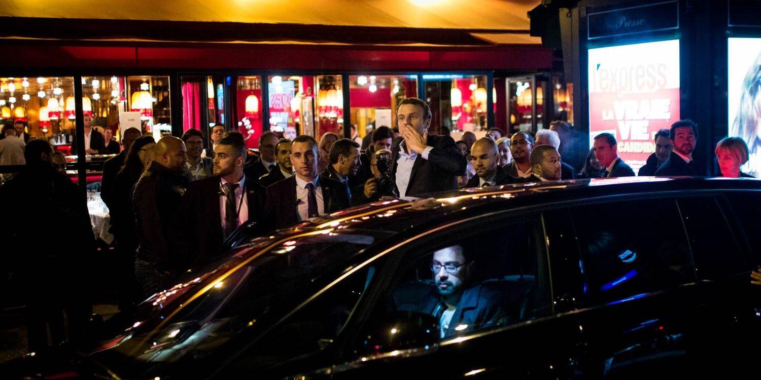 Emmanuel Macron kommer ut från en restaurang i Paris under valnatten.