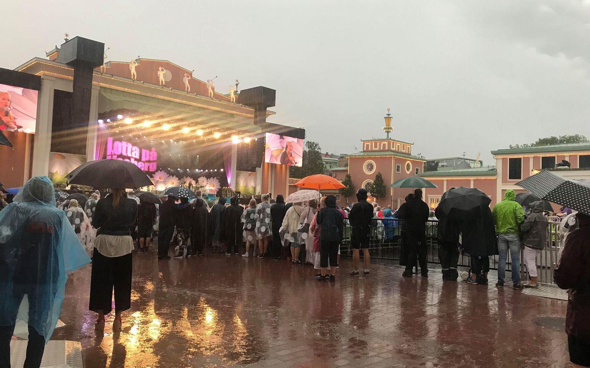 Många tappra musikälskare står framför scenen på Liseberg, trots regnet.