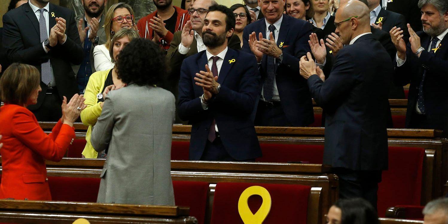 Den nye talmannen Roger Torrent, i mitten, gratuleras efter valet. Frånvarande ledamöters platser markerades med gula band, en symbol för stöd för de politiker som fängslats av Madrid.