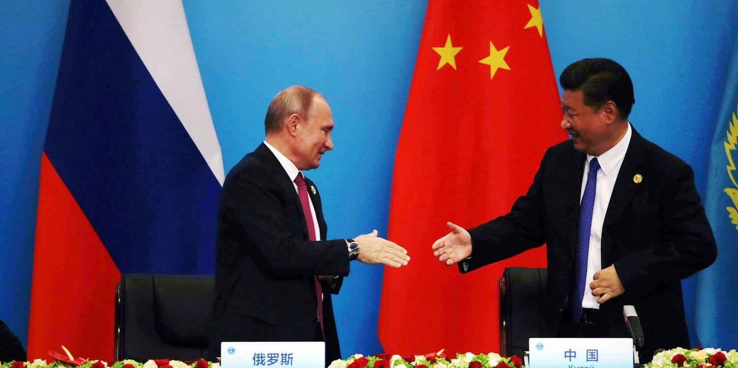 Kinas president Xi Jinping, till höger, skakar hand med Rysslands president Vladimir Putin efter deras gemensamma presskonferens i Qingdao på söndagen.