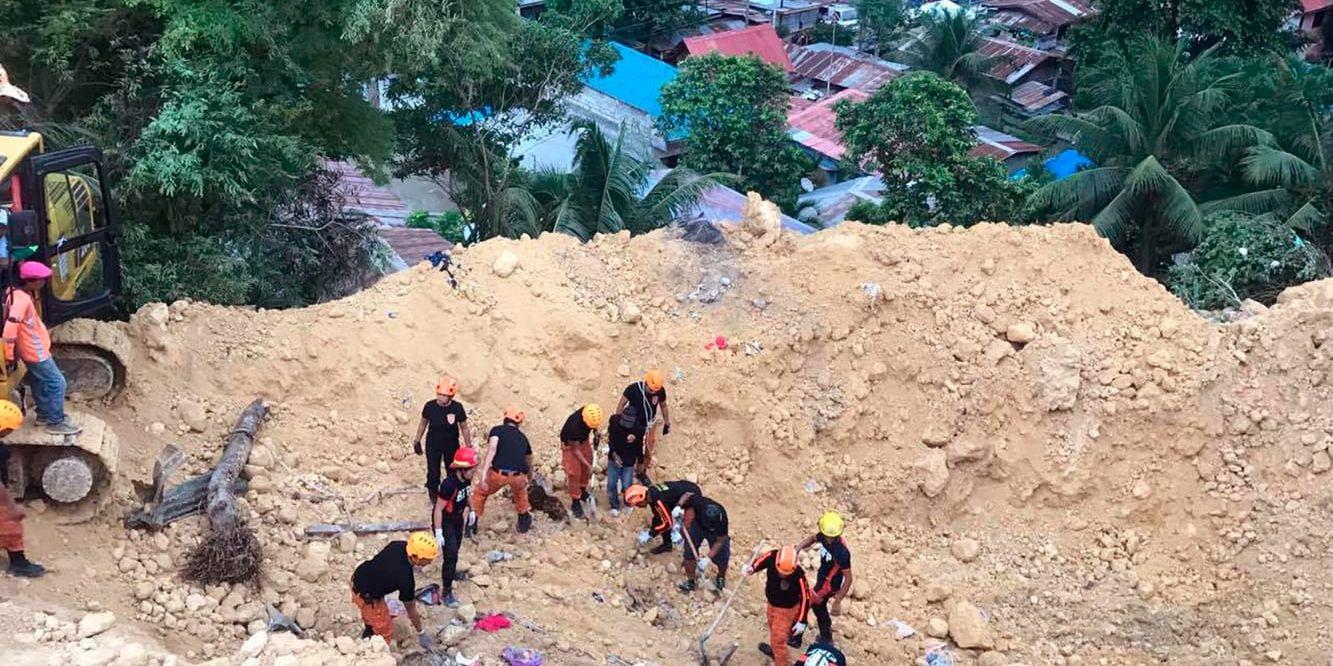 Räddningsarbetare letar efter överlevande efter ett jordskred nära Naga city i Filippinerna.