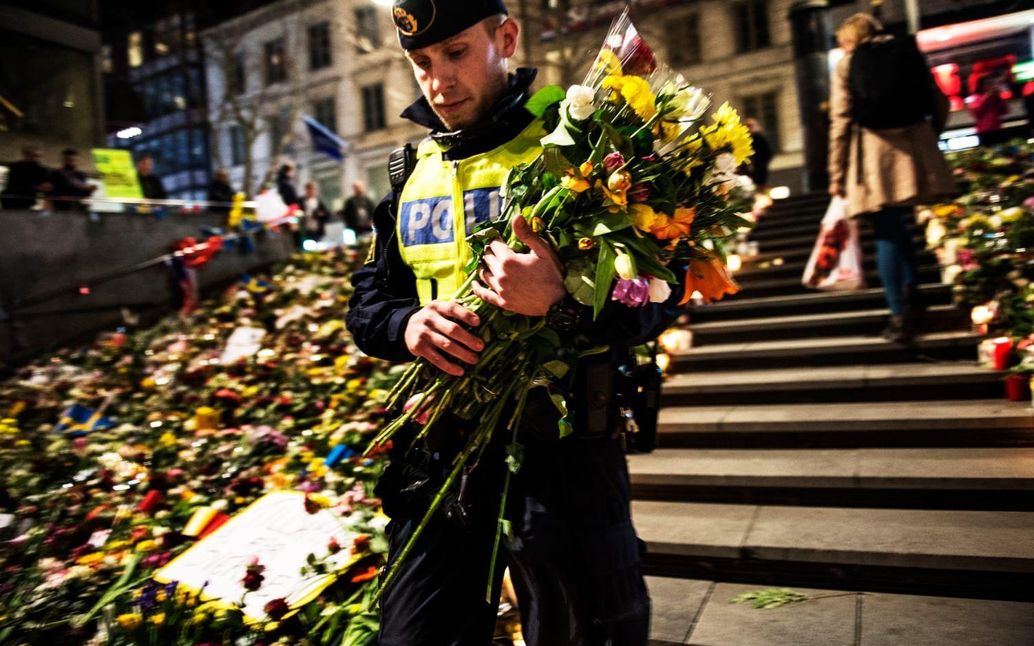 Polisen David placerade blommorna han och kollegan fått på Sergels torgs trappa. Bild: Stefan Berg.
