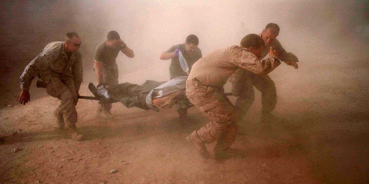 Amerikanska marinkårssoldater bär en kollega som skadats av en hemmagjord bomb i södra Afghanistan. Bilden är tagen 10 maj 2011. Arkivbild