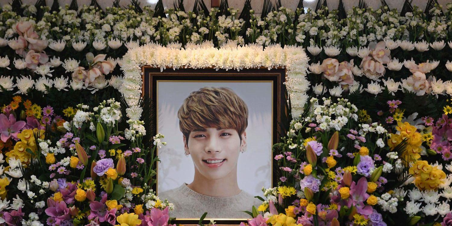 Ett porträtt av Kim Jong-Hyun omgivet av blommor efter sångarens död. Arkivbild.