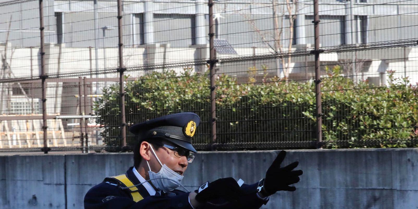En polis utanför den stora anläggning i Tokyo där Carlos Ghosn sitter inlåst.