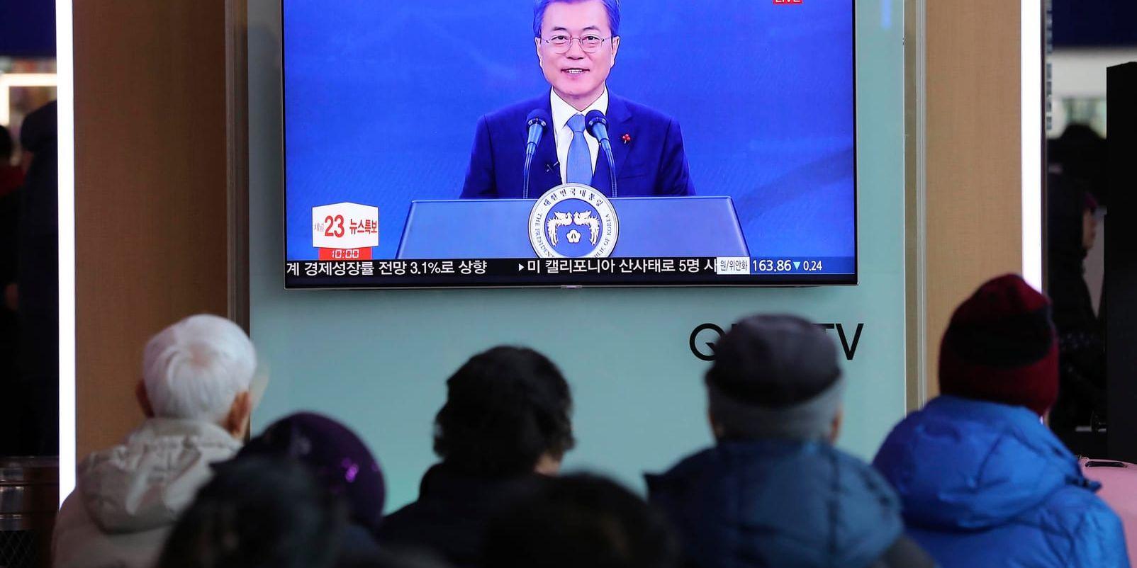 Resenärer på Seouls centralstation tittar på president Moon Jae-Ins tv-sända tal på onsdagen.