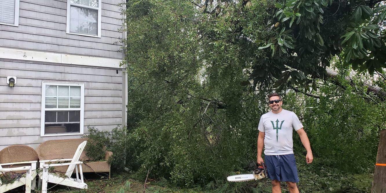 Jeremy Tominack är ute med motorsågen för att hjälpa grannar vars hus fått träd över sig.