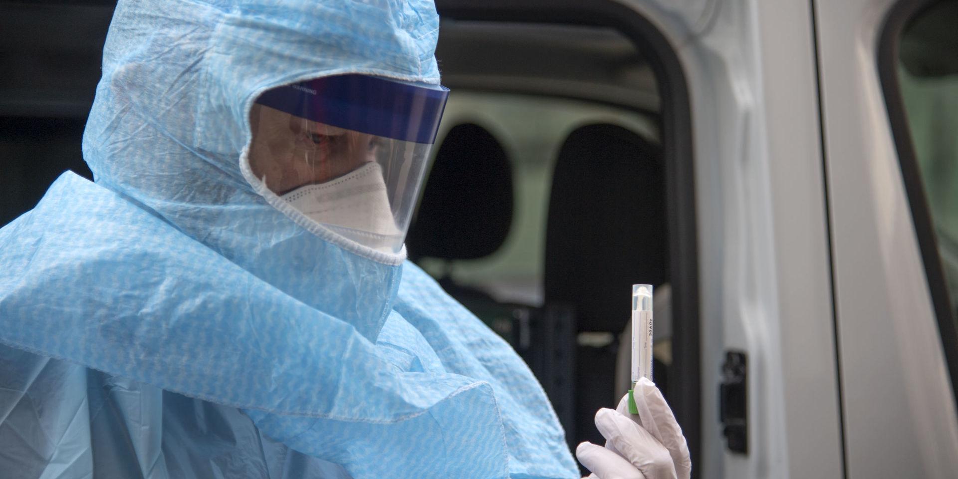 En svensk ambulanssjukvårdare visar upp ett provtagningskit för sars-cov-2, viruset som orsakar covid-19. Bild från i början av mars.