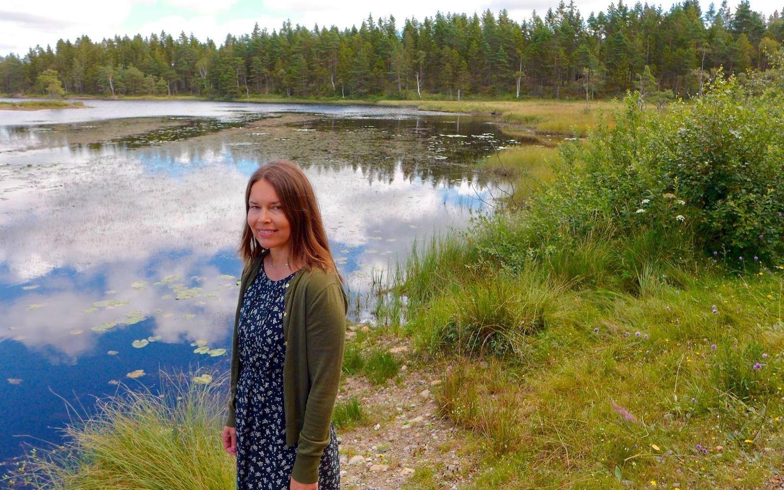 Nya succéförfattaren Susanne Jansson vid sjön och mossen där en del av handlingen utspelas i hennes debutroman. Bild: Kicki Media