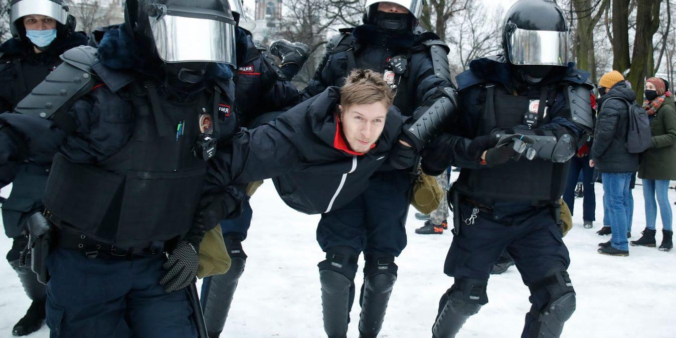 Poliser griper en Navalnyjanhängare under demonstrationen i Moskva.