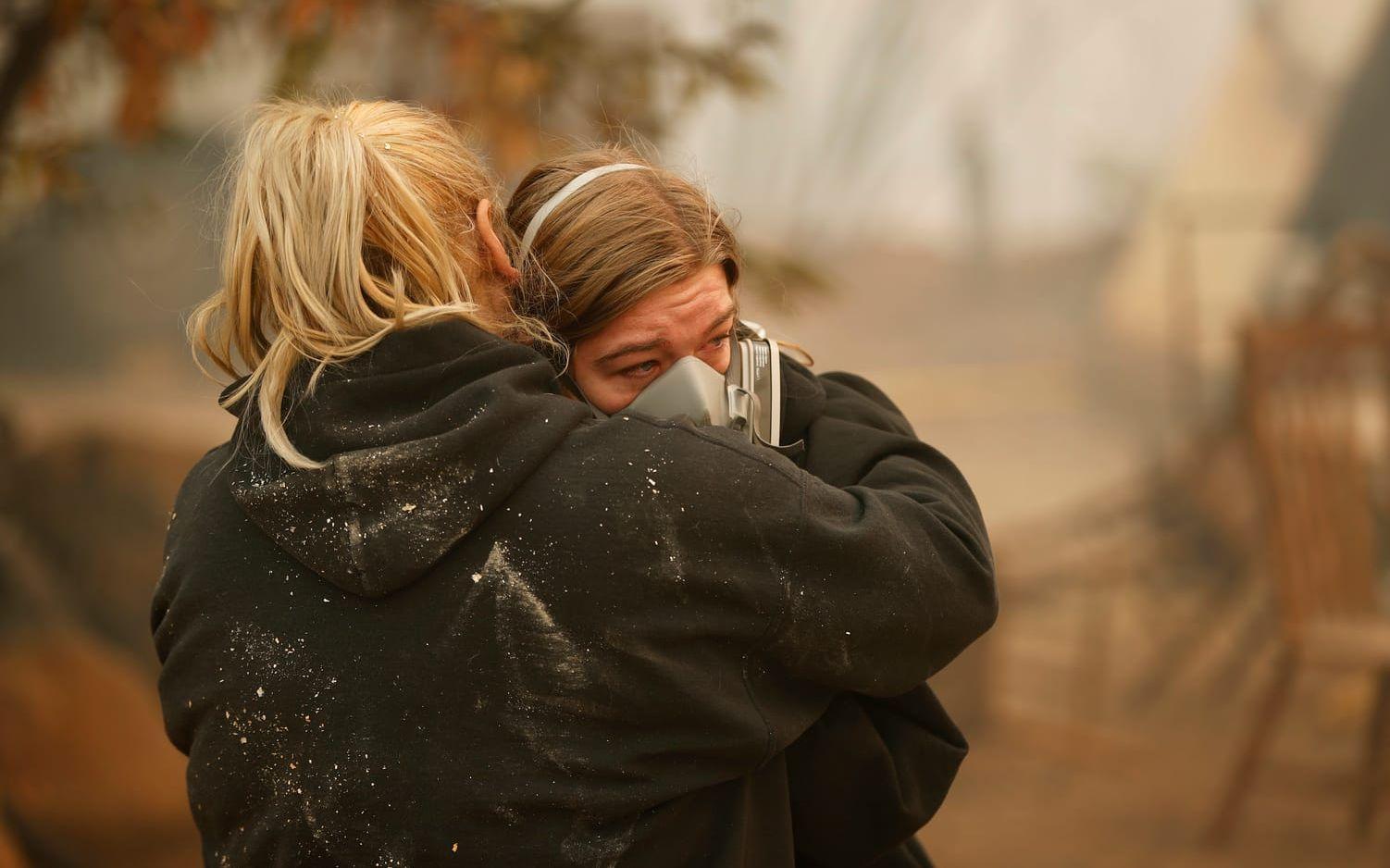 Krystin Harvey, till vänster, tröstar sin dotter Araya Cipollini vid resterna av deras hus. 