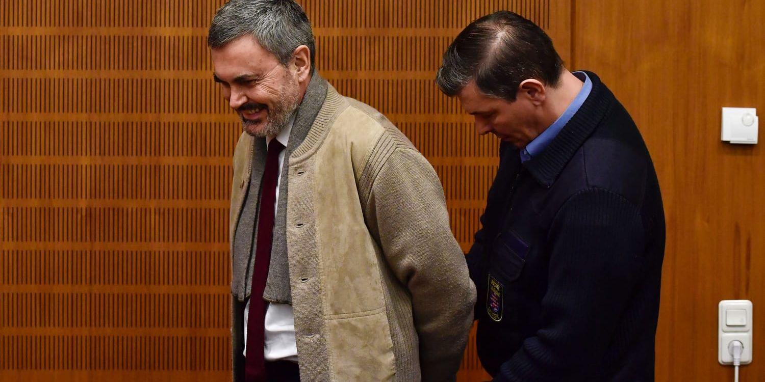 
John Ausonius, lasermannen,  förs in i rättssalen i Frankfurt. Han står inför rätta misstänkt för att ha mördat en kvinna i samma stad för 25 år sedan.