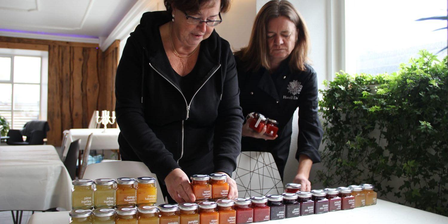 Tatiana Temm och Helena Dahlgren med några av alla marmelader tillverkade av säsongens bär och frukter i köket på Hedefors bruk. Bild: Camilla Moestedt